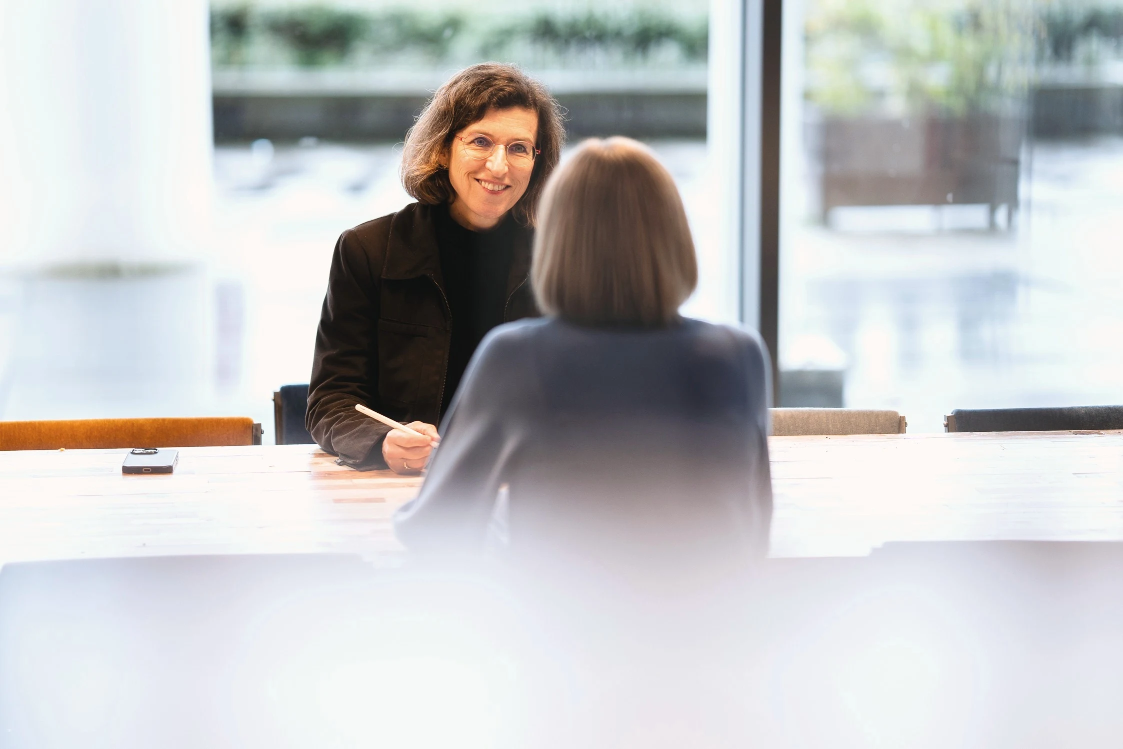 A performance advisor in conversation across a table, diagnosing a request before deciding on a remedy.