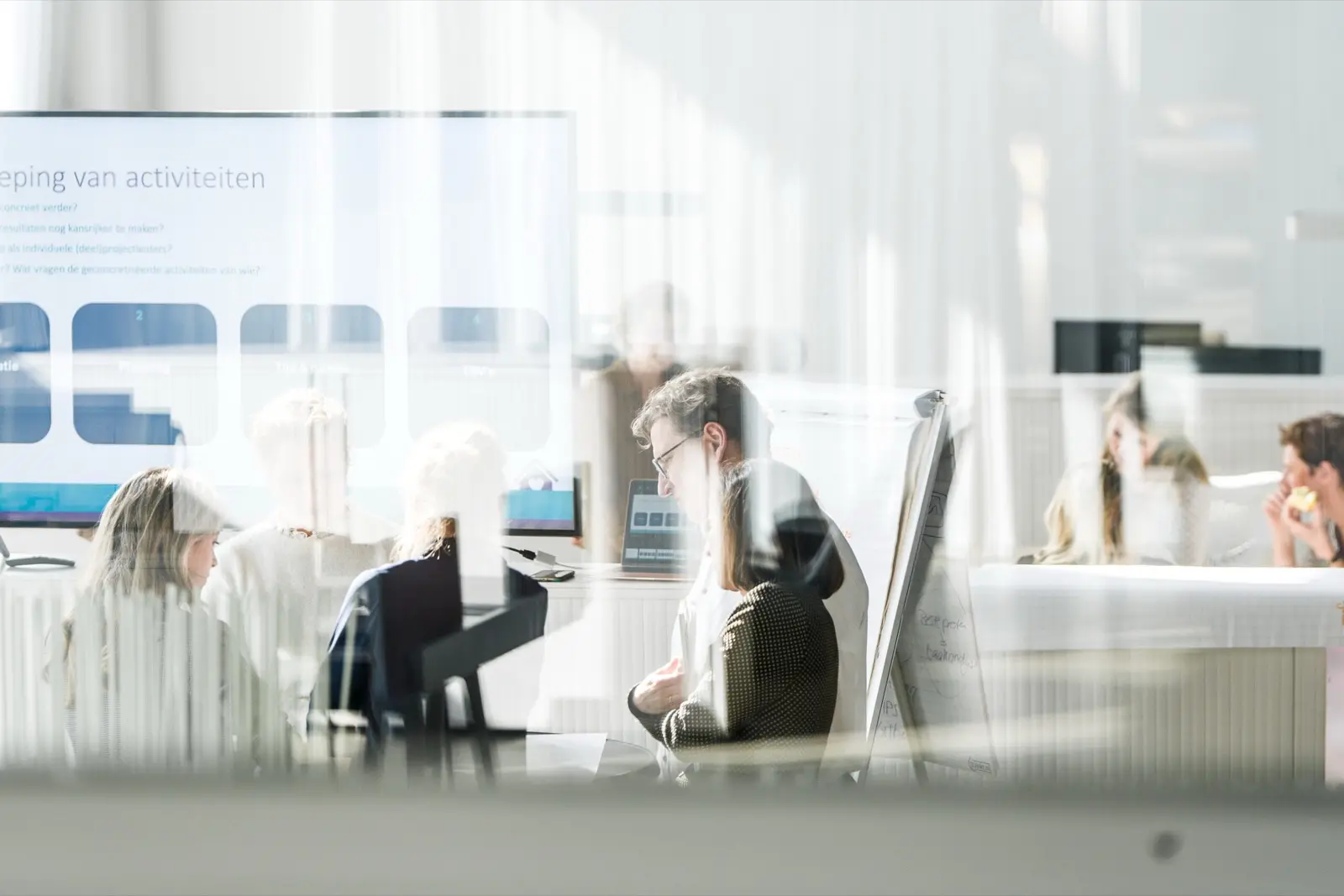 Een medewerker aan het werk, gezien door het glas
