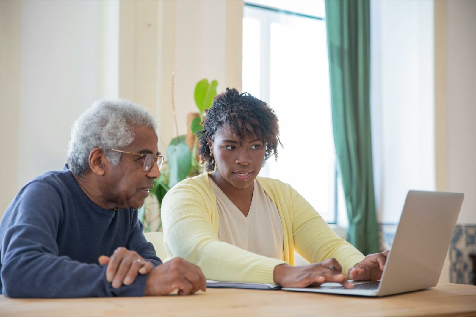 Begeleider en lerende kijken samen naar een laptop