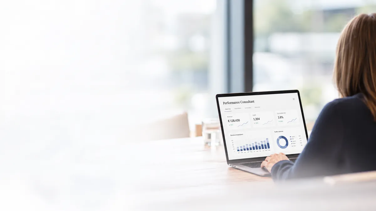De Performance Consultant AI open op een laptop, aan tafel bij het raam