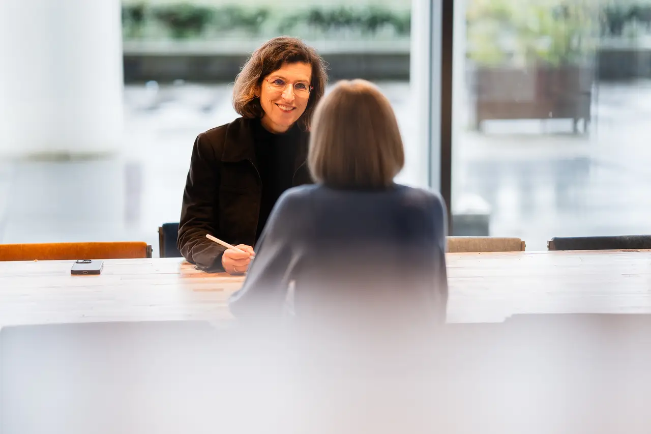 Een intakegesprek aan tafel bij het raam